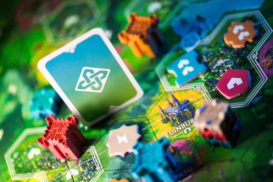 Board game with colorful cards and pieces on a green board