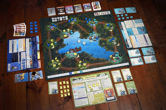 Root clockwork 2 Board game with various cards and pieces on a wooden floor