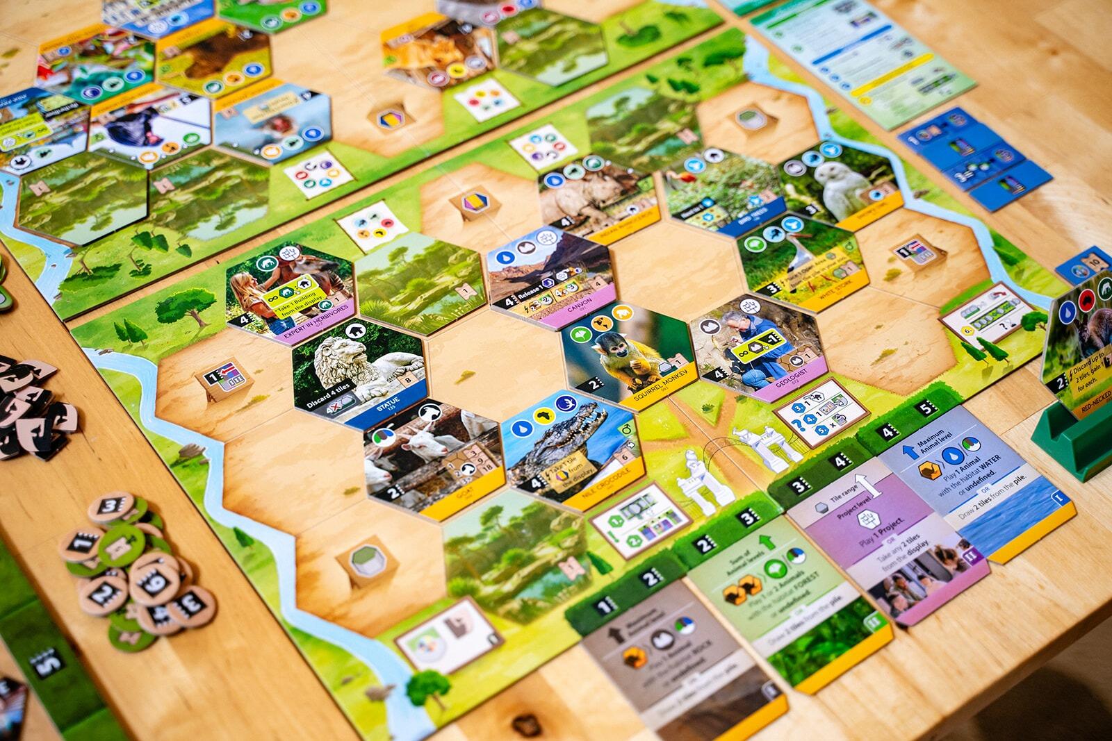 Sanctuary Board game with various cards and pieces on a wooden table