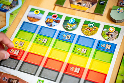 Sanctuary Ark Nova Board game with colorful tiles and a hand placing a red tile