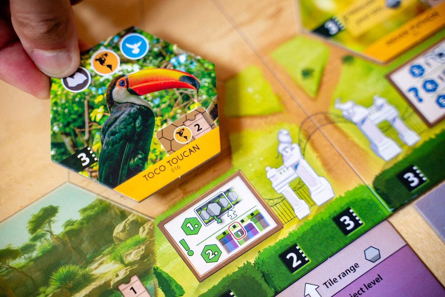 Sanctuary Board game piece with toucan illustration on a game board