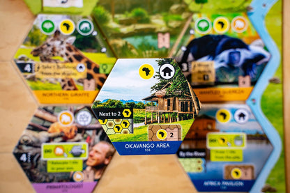 Sanctuary game board piece with scenic illustration and text on a wooden surface