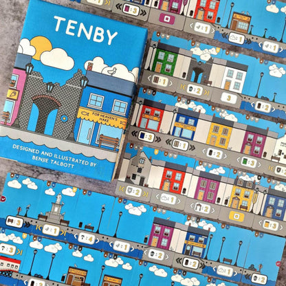 Board game titled 'Tenby' with colorful illustrations of a town on a blue background.