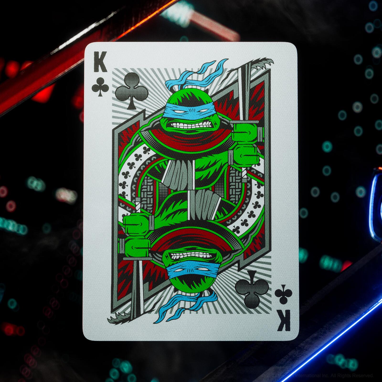 Playing card with a king of clubs design featuring a green character on a dark background with colorful lights.