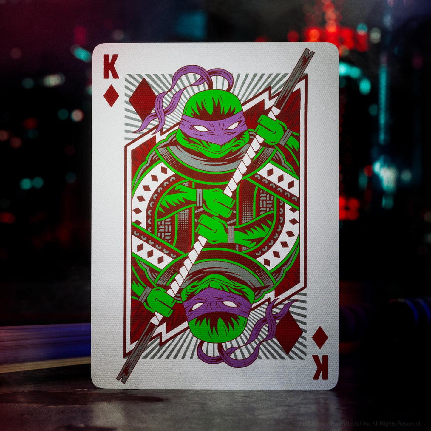 Playing card with a green character design on a dark background
